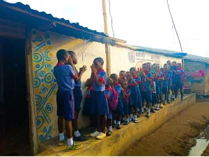 Two boys sitting on a wooden boat on a river in Nigeria